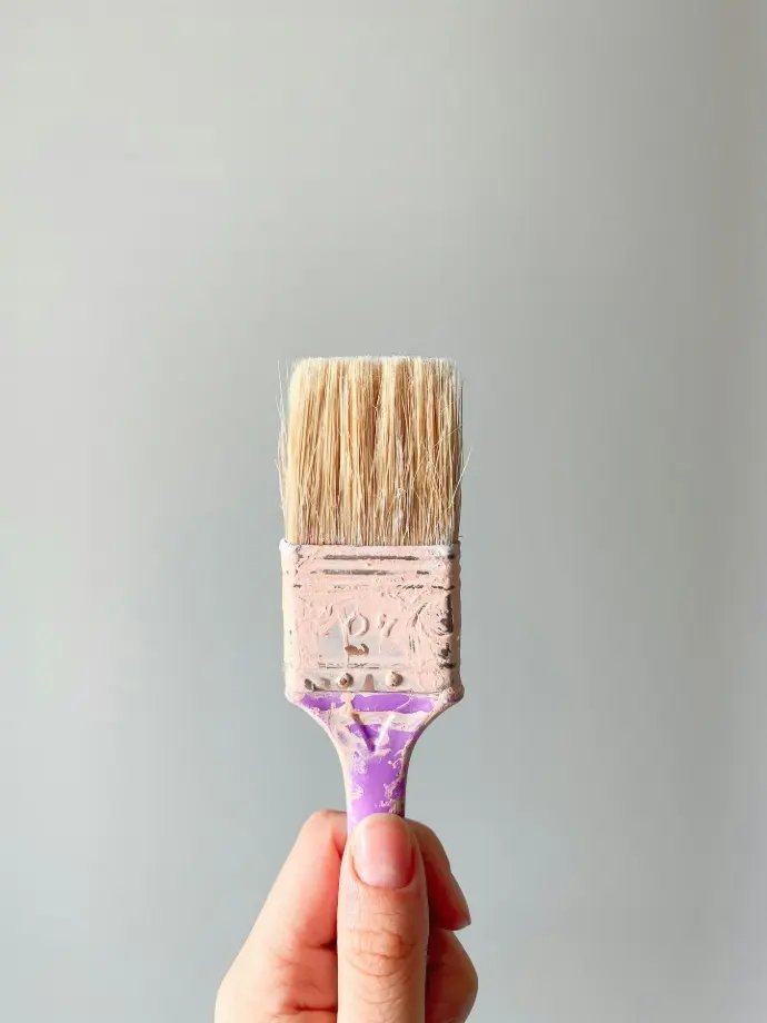 person holding brown and gray paint brush
